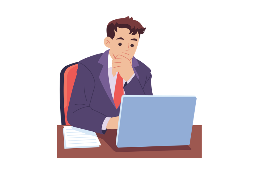 Business professional sitting at a desk and working on a laptop